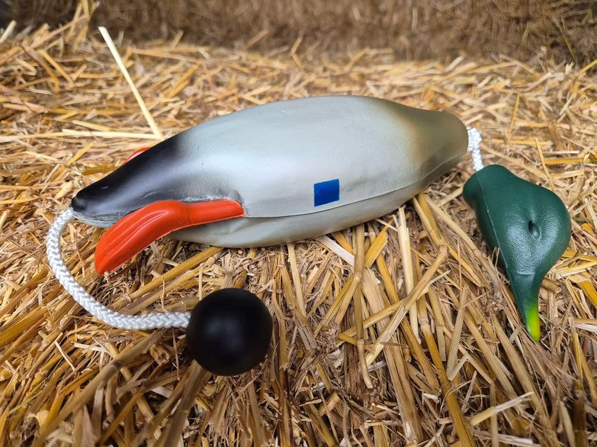 Kirkbourne Spaniels KB baby mallard dummy resting on hay bale - lightweight lifelike mallard dummy with swinging head and throwing toggle for puppy introduction and water retrieve training