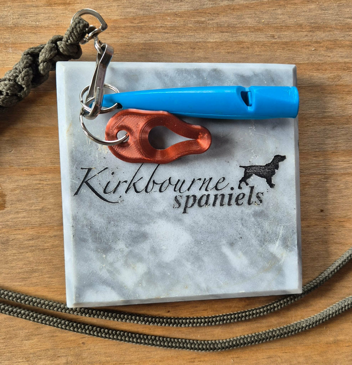 Kirkbourne Spaniels copper tick puller shown alongside gundog whistle for size reference - compact PLA bioplastic straight-pull tick removal tool for keyring lanyard or game bag clip
